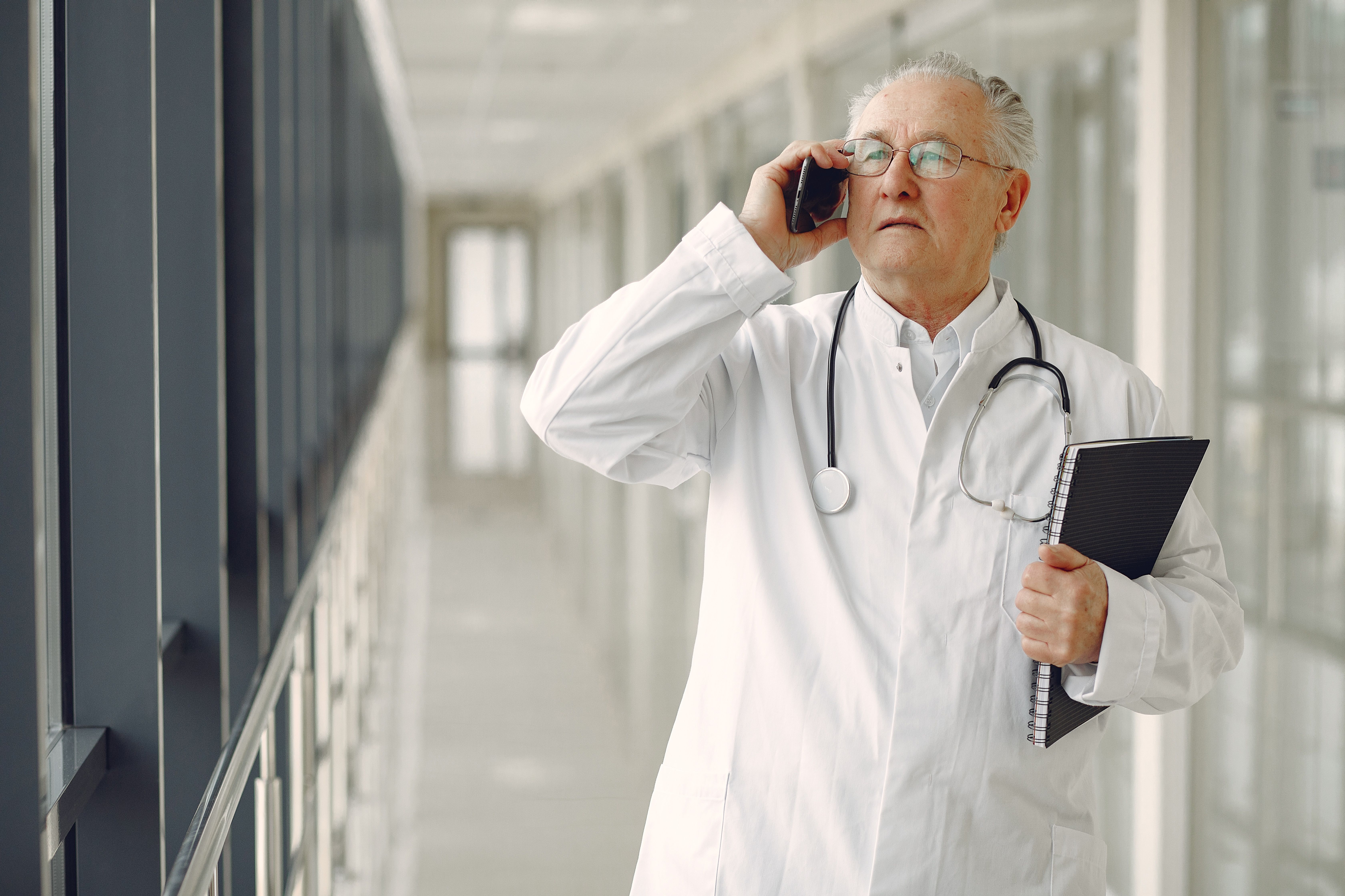 Doctor speaking on the phone while walking through a hospital hallway